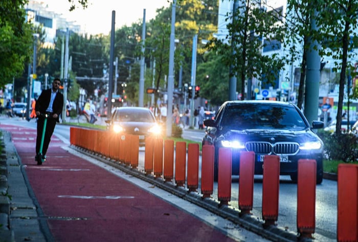 Rettungskräfte werden ausgebremst, wo Autofahrer im Stau nicht mehr ausweichen können  Da Autofahrer immer öfter wegen Radwegtrennern wie in der Konrad-Adenauer-Straße nicht ausweichen können, wird es für Feuerwehr und Rettungsdienst schwieriger, durch die Stadt zu kommen. FOTO: Rainer Rüffer  Frankfurt - Aufgrund der zunehmenden Zahl geschützter Radwege kommen Rettungswagen und Feuerwehr immer schlechter durch Frankfurt. Was bisher bereits mehrere Hilfsorganisationen sowie ein Berufsfeuerwehrmann in dieser Zeitung anmerkten, bestätigt nun auch die städtische Branddirektion offiziell.  Seit vier Jahren widmet die Stadt Fahrstreifen in Fahrradfahrspuren um. Wo sie mit Trennelementen abgeschirmt werden, ist bei Stau oft kaum noch ein Durchkommen, kritisieren die Rettungskräfte. „Bei baulichen Abtrennungen wird die Bildung einer Rettungsgasse durch den Individualverkehr erschwert oder verhindert“, bestätigt Andreas Mohn, der Sprecher von Branddirektor Karl-Heinz Frank, dem Chef der Berufs- und der 28 freiwilligen Feuerwehren.  Branddirektion an Planung „nicht beteiligt“  „Das kostet uns einfach deutlich mehr Zeit“, hatte ein Berufsfeuerwehrmann anonym in dieser Zeitung dargestellt. „Genaue Zahlen für Fahrtzeiten können im Zusammenhang mit Fahrspurabtrennungen nicht dargestellt werden“, räumt die Branddirektion ein. Neben der Feuerwehr haben bisher drei der vier im Stadtgebiet tätigen Rettungsdienste auf verlängerte Einsatzzeiten hingewiesen, da Autos und Laster vor allem wegen Radwegtrennern schlechter ausweichen können. Die ersten Separatoren für mehr Sicherheit der Radler hatte die Stadt Anfang 2020 in der Konrad-Adenauer-Straße nördlich der Konstablerwache installiert. „Die Feuerwehr akzeptiert sie, weil sie im Alarmfall für ein robustes Feuerwehrfahrzeug überfahrbar sind“, hatte der Fahrradclub ADFC seinerzeit gelobt. Allein: Die Berufsfeuerwehr sieht das ganz anders.  „Die Branddirektion war an dieser Maßnahme nicht beteiligt“, erklärt Sprecher Mohn. „Eine Stellungnahme wurde nicht abgegeben.“ Allerdings könnten Einsatzfahrzeuge in der Adenauer- und der Kurt-Schumacher-Straße die Kombispur in der Straßenmitte nutzen. Das sieht ein Berufsfeuerwehrmann anders, der von der Wache 4 in Sachsenhausen aus oft dort unterwegs ist. „Wenn da eine Straßenbahn oder ein Bus fährt, fahren wir da nicht entlang, damit wir nicht dahinter festhängen.“ Trams und Busse rollen hier im Minutentakt. Die Branddirektion räumt ein: Die „Nutzung von Schienen-/Buswegen“ sei „natürlich grundsätzlich nur bei freier Befahrbarkeit möglich“, das sei „also keine jederzeit uneingeschränkte Option“.  Die Feuerwehr werde „selbstverständlich“ eingebunden, bevor eine geschützte Fahrradspur eingerichtet werde, betont Ingmar Bolle, Vizechef des Straßenverkehrsamts. So sei die Branddirektion Teil der „Koordinierungsgruppe Verkehr“, die über „größere Vorhaben“ entscheide. Ohne Okay der Wehr geschehe nichts. „Im Alltagsgeschäft erhält die Branddirektion alle verkehrsrechtlichen Anordnungen von uns in Durchschrift, die mehr als nur geringe Auswirkungen auf das Verkehrsgeschehen haben“, erklärt Ingmar Bolle. Das betreffe etwa Sperrungen wegen Bauarbeiten. „Verkehrsführungsänderungen oder Radverkehrsmaßnahmen werden ebenfalls mit der Branddirektion vorabgestimmt“. Das Prozedere habe sich bewährt.  Anders als es der ADFC darstellt, sind offenbar auch die Trennelemente selbst ein Problem. Die Fahrzeugmeisterei der Feuerwehr habe eine „ausgiebige Erprobung und Bewertung der baulichen Trennelemente vorgenommen“, erklärt zwar der Straßenverkehrsamtsvize. Was verbaut werde, „berücksichtigt die Bedürfnisse der Branddirektion“. Auch würden für die Feuerwehr Lücken gelassen wie am Güterplatz.  Fahrzeuge beschädigt, Leitungen abgerissen  Die Tests der Feuerwehr aber zeigen: „Bei Überfahrversuchen aufgesetzter Elemente kam es zu Beschädigungen von Fahrzeugteilen und Abrissen von Leitungen an der Karosserie.“ Aus dem Rettungsdienst ist zu hören, dass keiner über die Trenner fährt. „Niemand will sich einen Reifen kaputtfahren“, erklärt Oliver Pitsch, Regionalvorstandsmitglied bei den Johannitern. Bleibe ein Rettungswagen deshalb liegen, helfe das auch dem Patienten nicht.  Zumal: „Für Patienten sind Erschütterungen durch das Überfahren von aufgesetzten Fahrbahnteilern äußerst unangenehm“, mahnt die Branddirektion. Die Sperren verhinderten aber vor allem, dass Autofahrer Platz machen. Nähere sich ein Einsatzwagen mit Blaulicht und Martinshorn und sie könnten nicht ausweichen, „bedeutet das Stress für Autofahrer“, warnt Dierk Dallwitz, Bezirksverbandsgeschäftsführer des Roten Kreuzes. Reagierten sie unachtsam, werde es „noch gefährlicher für Radfahrer und Fußgänger“.  Die Stadt wolle künftig nur noch überfahrbare Separatoren installieren, kündigt Mobilitätsdezernent Wolfgang Siefert (Grüne) an. Es gebe bei der Stadt „Lerneffekte“. Siefert hatte bereits angekündigt, dass die Stadt als Folge der Kritik der Retter Fahrradspuren künftig generell breiter gestaltet. Das fordert auch Ansgar Hegerfeld vom ADFC: „Radwege müssen so breit und frei von Falschparkern sein, dass auch Rettungsdienste diese problemlos nutzen können.“ Dennis Pfeiffer-Goldmann  KOMMENTAR  Von der autogerechten zur rein fahrradgerechten Stadt  VON DENNIS PFEIFFER-GOLDMANN  Mehr Schutz für die einen, weniger für die anderen: Radwegtrenner scheinen nicht die beste Lösung für die Neuordnung auf Frankfurts Straßen zu sein. Zumindest nicht so, wie die Separatoren bisher installiert werden. Dass Straßenverkehrsamt und Feuerwehr die Lage so unterschiedlich sehen, ist bedenklich. Ist die Branddirektion übervorsichtig? Oder agiert das Mobilitätsdezernat zu forsch? Für Letzteres spricht bereits das Vorgehen bei der fahrradfreundlichen Umgestaltung im Oeder Weg. Dort „gestalten“ Grüne, SPD, FDP und Volt gleich noch die Einzelhandelslandschaft um. Nun droht die nächste Übergriffigkeit, sollten Fahrradspuren generell überbreit werden, damit Rettungswagen durchpassen. Wird die autogerechte etwa direkt zur rein fahrradgerechten Stadt umgebaut? Besser nicht. Dieser Drahtesel-Aktivismus geht nicht nur am Bedarf vorbei, er ist ja auch noch für andere gefährlich. Die Verkehrspolitik sollte eiligst auf einen maßvollen Mittelweg umlenken.